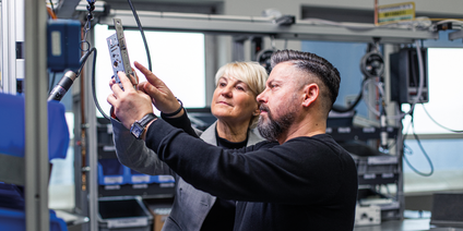 Fachkräfte prüfen Metallbauteil gemeinsam