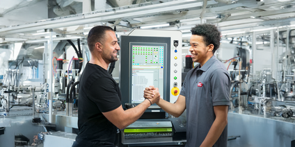 Zwei Mitarbeiter vor Steuerungsgerät