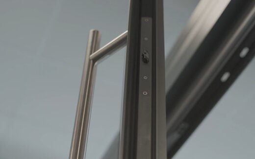 Edelstahlgriff an schwarzer Glasschiebetür und Mehrfachverriegelung