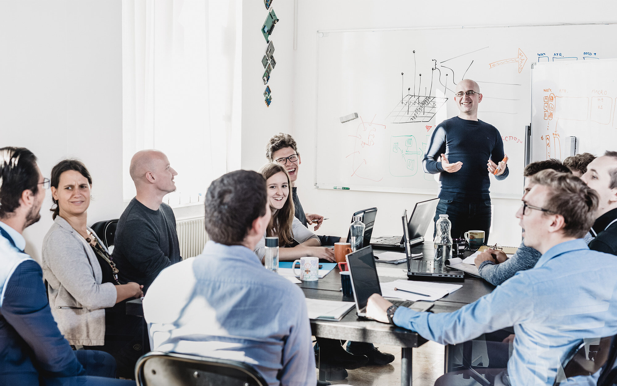 Team in einem Seminar mit Whiteboard und Laptops