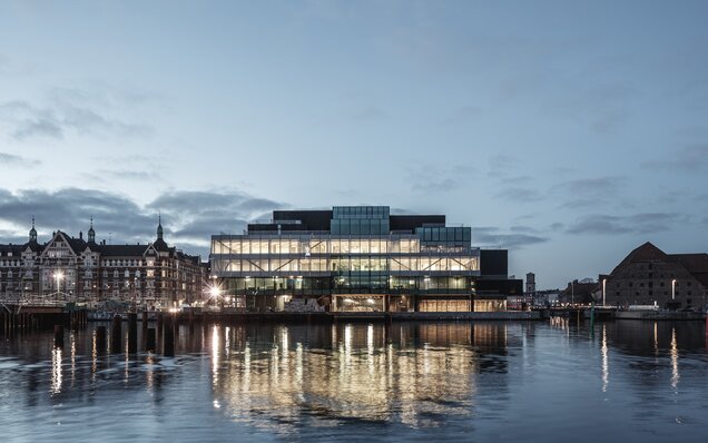 Beleuchtetes Gebäude am Wasser bei Dämmerung