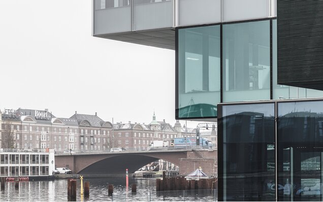 Glasfassade mit Brücke und Altbau
