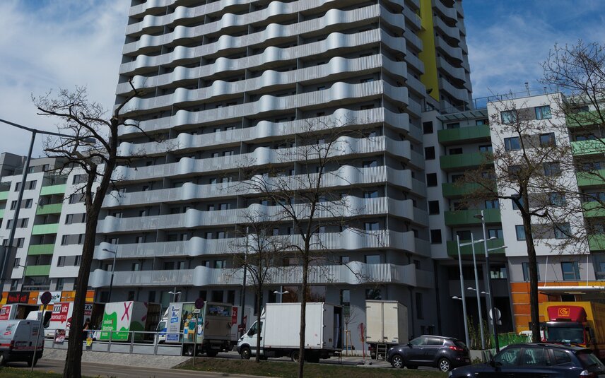 Wohnhaus mit auffälligen Balkonen und Fahrzeugen