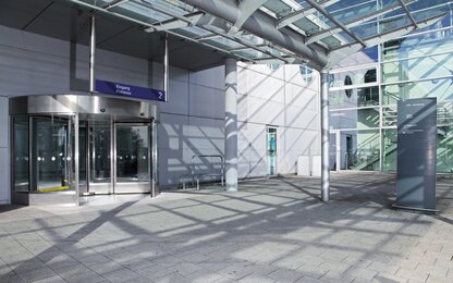 Eingang mit Drehtür und Wegweiser