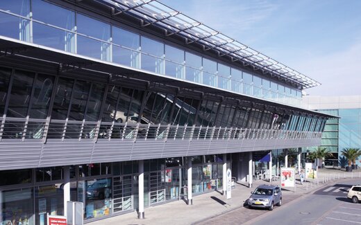 Flughafenterminal mit Parkplätzen und Autos