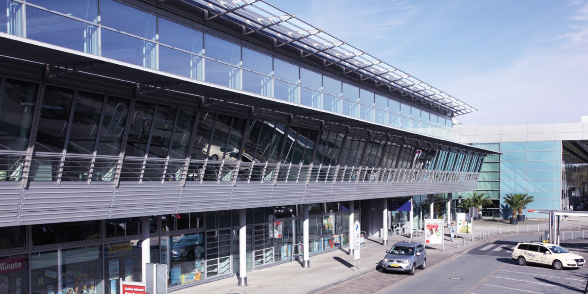 Flughafenterminal mit Parkplätzen und Autos