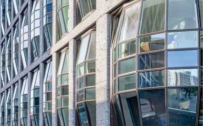 Gebogene Glasfassade mit Ziegelsteinverkleidung