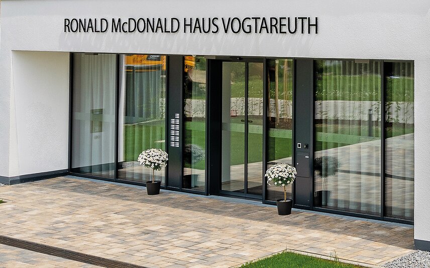 Eingang mit Glasfassade und Blumendekor