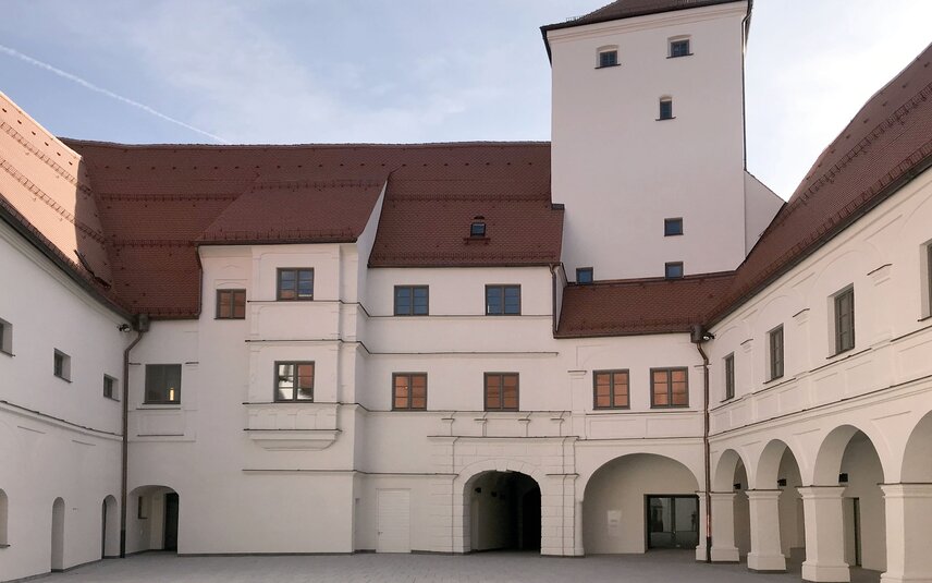Innenhof mit Arkaden und weißer Fassade