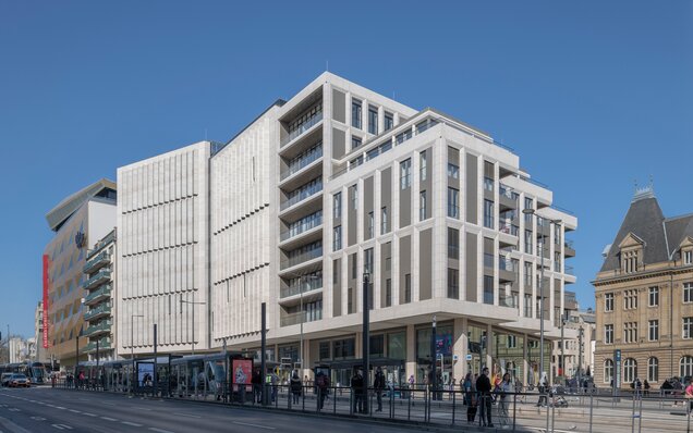 Modernes Gebäude mit Straßenbahn und Menschen